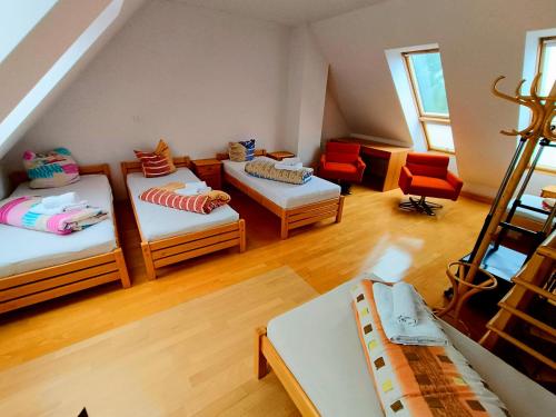 Bovec Garni Apartment 7 في بوفيك: غرفة علوية بثلاث اسرة وكرسيين