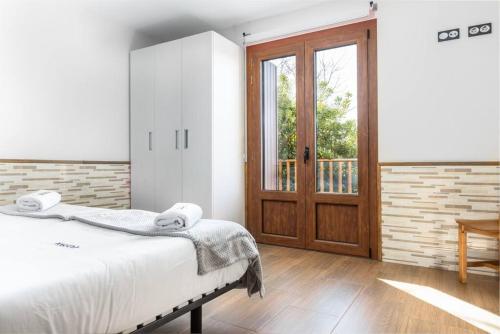 a bedroom with a bed and a wooden door at MUNALLA-IDEAL FAMILIAS Y AMIGOS. SENDERISMO. in Aia
