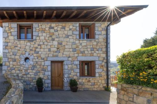 a stone house with a wooden door in front of it at MUNALLA-IDEAL FAMILIAS Y AMIGOS. SENDERISMO. in Aia