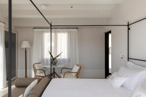 a bedroom with a large bed and a table at Hotel Le Dune Piscinas in Ingurtosu