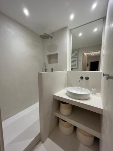 une salle de bain blanche avec un lavabo et un miroir dans l'établissement Le Refuge Présidentiel : Charme et Commodités, à Le Touquet-Paris-Plage