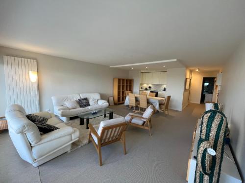 - un salon avec des canapés et des chaises blancs dans l'établissement Le Refuge Présidentiel : Charme et Commodités, à Le Touquet-Paris-Plage