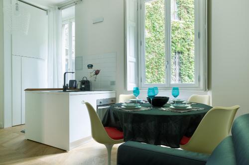 eine Küche mit einem Tisch und Stühlen sowie eine Küche mit einem Tisch und einer Küche in der Unterkunft HL Apartment - Sant'Ambrogio, Duomo in Mailand