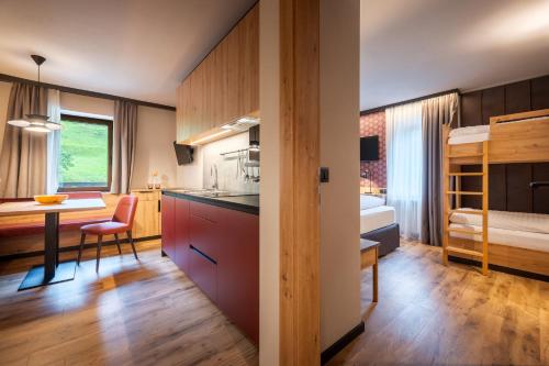 ein Zimmer mit einer Küche und ein Schlafzimmer mit einem Bett in der Unterkunft Family Apartments Vioz in Peio Fonti