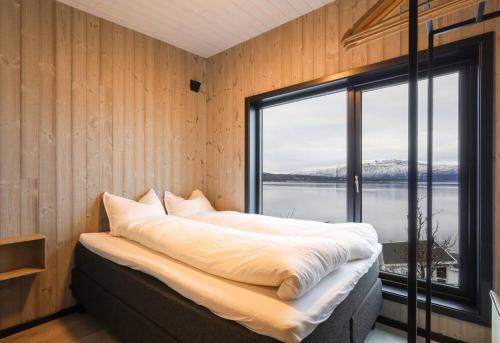 a bedroom with a large bed with a large window at Luksus panorama hytte -H24 in Mestervik