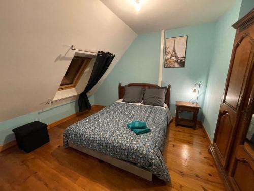een slaapkamer met een bed met een groen kussen erop bij Appart' Privé à Issoudun : Confort et Style in Issoudun