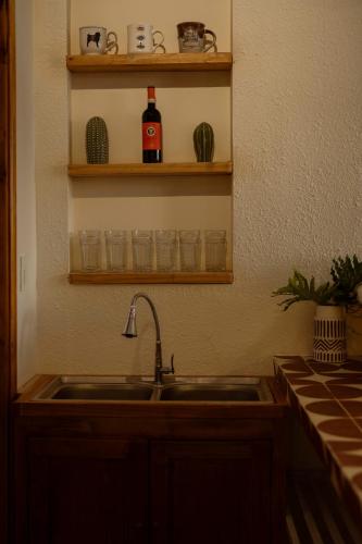 a kitchen sink with a bottle of wine on a shelf at Country Road Villa in Xuyên Mộc