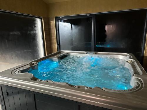 a hot tub with blue water in a bathroom at Cabana The One in Beliş