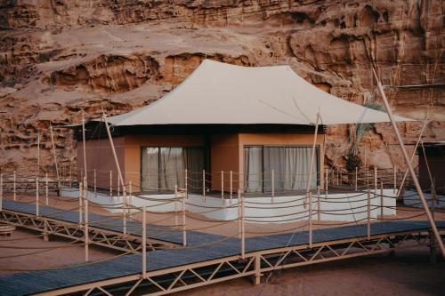 ein Gebäude in einer Felswand mit einem Zelt in der Unterkunft Valley Resort in Wadi Rum