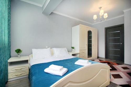 1 dormitorio con 1 cama con 2 toallas en ЖК Айгерим, en Almaty