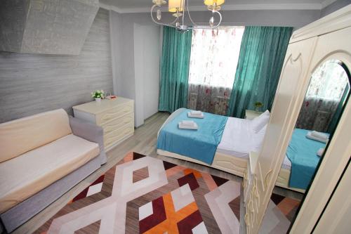 a small bedroom with a bed and a couch at ЖК Айгерим in Almaty