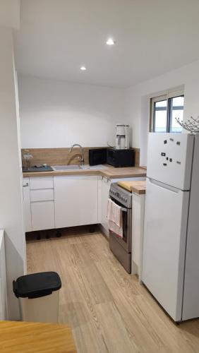 une cuisine avec des appareils blancs et un parquet dans l'établissement Petit séjour en chalet, à Crécy-la-Chapelle