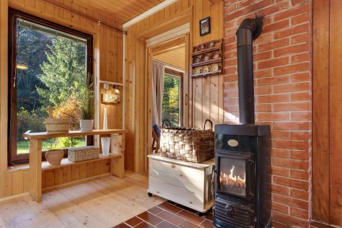 a fireplace in a room with a brick wall at Cabin by the river with Sauna in Polhov Gradec