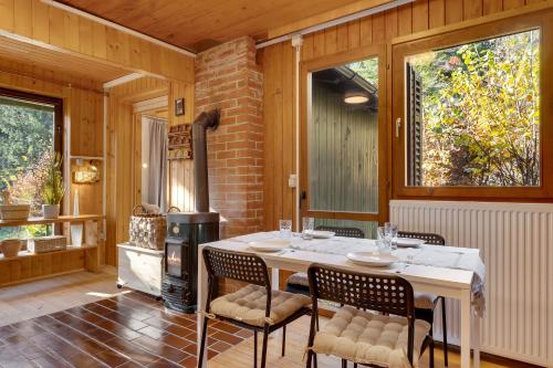 a dining room with a table and chairs and a stove at Cabin by the river Polhov Gradec in Polhov Gradec
