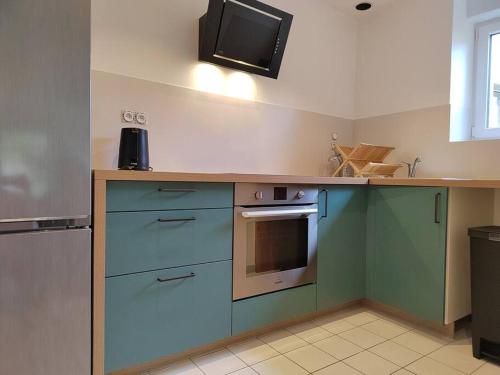 uma cozinha com armários azuis e uma bancada em Maison au coeur de ville parking em Paimpol
