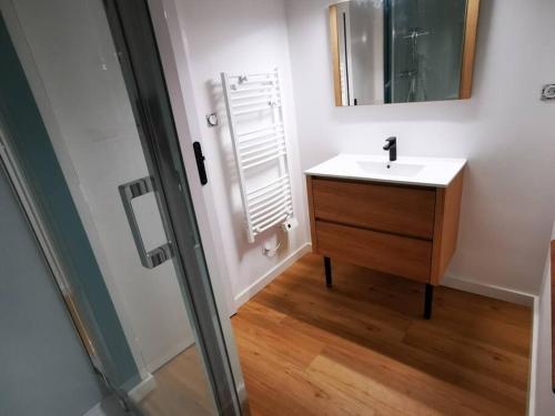 une salle de bain avec un lavabo et un miroir dans l'établissement Maison au coeur de ville parking, à Paimpol