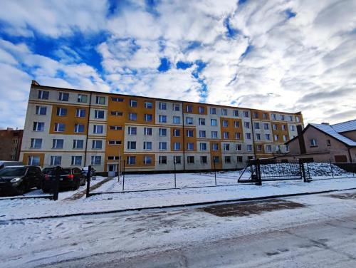 a large yellow building with snow in front of it at Płonia Economy in Szczecin