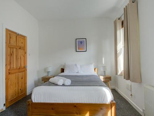 een slaapkamer met een bed met witte lakens en een raam bij Pass the Keys Colourful property sleeps 6 in Manchester