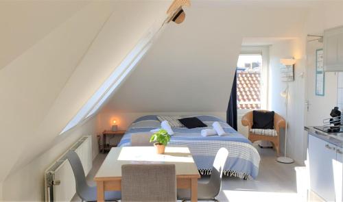 a bedroom with a bed and a table in a room at Pension Zandvoort aan Zee in Zandvoort