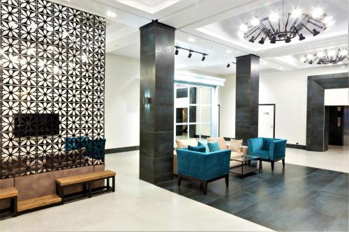 a lobby with blue chairs and a fireplace at MIRAMAR Apart Hotel & SPA in Aktau