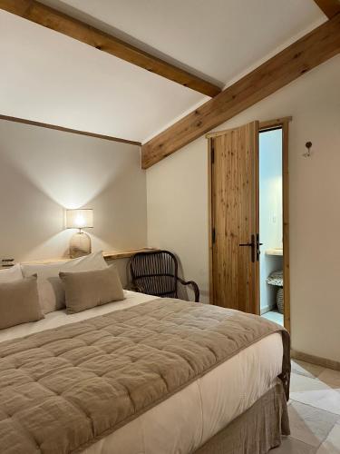 une chambre avec un grand lit et une chaise dans l'établissement La Maison des Chênes - 5 étoiles, à Cavalaire-sur-Mer