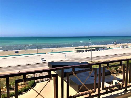 a view of a beach and the ocean from a balcony at MIRAMAR Apart Hotel & SPA in Aktau