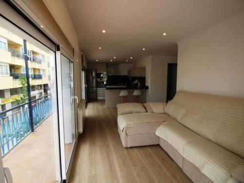 een woonkamer met een bank en een balkon bij Apartamento Llançà, 3 dormitorios, 5 personas - ES-228-68 in Llança