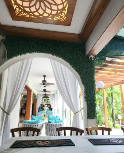a dining room with green walls and tables and chairs at La Fattoria Resort in Mombasa
