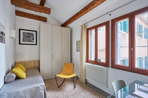 1 dormitorio con 1 cama y 1 silla amarilla en Cà Boldo Terrace 2.0, en Venecia