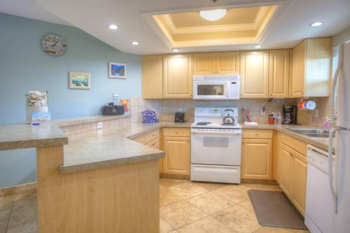 a kitchen with wooden cabinets and a white stove top oven at 306 - Gulf Strand in St. Pete Beach