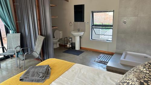 a bathroom with a bed and a sink and a toilet at Dullstroom Selfcatering Blue Crane Estate in Dullstroom