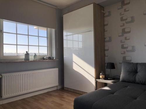 a living room with a bed and a window at Marbijes Appartementhaus in Cuxhaven