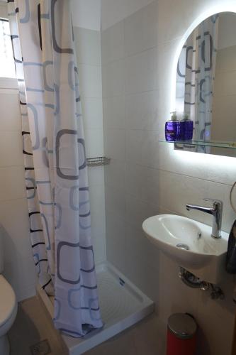 a bathroom with a sink and a shower curtain at Studio in Villa in Kalloni direkt am Meer in Kalloni