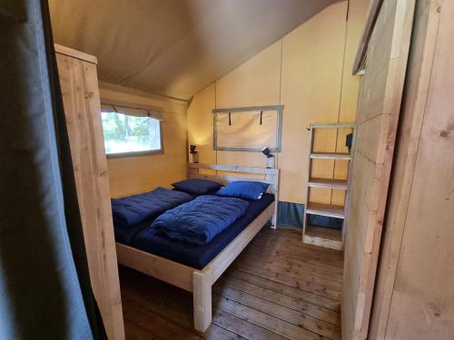 a bedroom with a bed in a tiny house at Camping Village Sy in Ferrières
