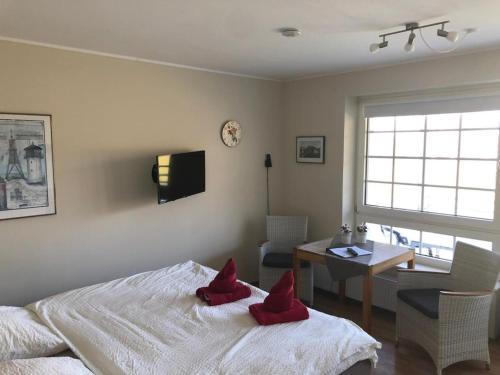 ein Schlafzimmer mit einem Bett mit roten Kissen darauf in der Unterkunft Marbijes Appartementhaus in Cuxhaven