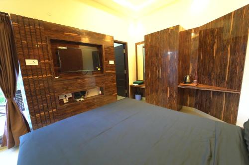 1 dormitorio con 1 cama y TV en la pared en Melody Inn en Yercaud