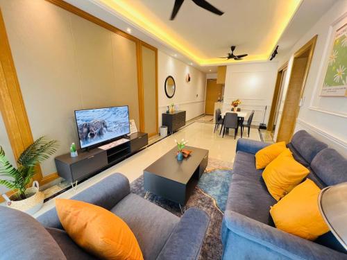 a living room with a blue couch and a flat screen tv at R&F PRINCESS COVE at ANJU in Johor Bahru