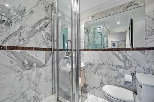 a bathroom with a shower and a toilet and a sink at Finest Retreats - Hollybank House in London