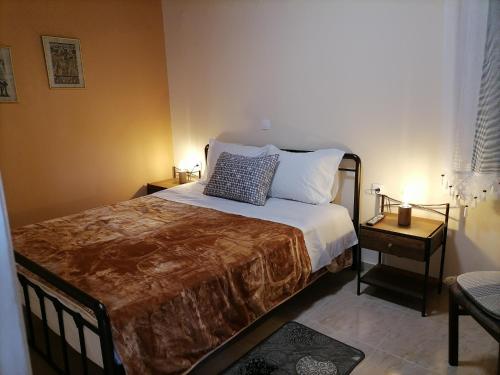 um quarto com uma cama e uma mesa com um candeeiro em House in Amfilochia- Μονοκατοικία em Amfilochia
