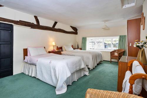 a bedroom with two beds and a window at Finest Retreats - No 2 Town Head Cottages in Grasmere