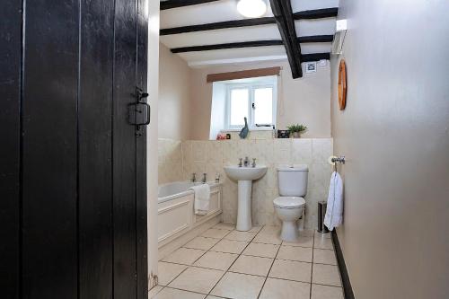 uma casa de banho com um WC, uma banheira e um lavatório. em Finest Retreats - No 2 Town Head Cottages em Grasmere