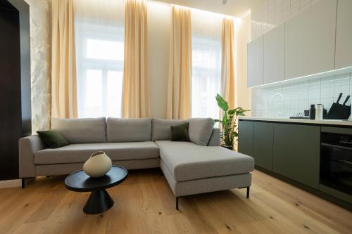 sala de estar con sofá y cocina en Brand-new 2-room apartment with a king size bed en Viena