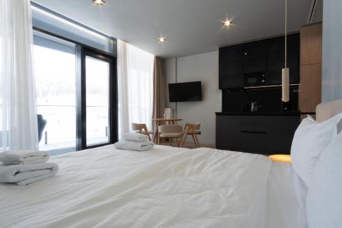 a bedroom with a large white bed with towels on it at SAVOIE Apartments Bukovel in Bukovel