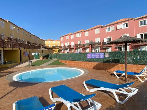 een zwembad met 2 ligstoelen en een parasol bij Casa Greta in Costa de Antigua