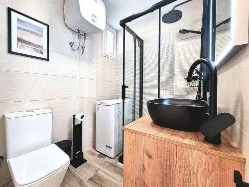a bathroom with a black sink and a toilet at Un pisito en Maspalomas in Maspalomas
