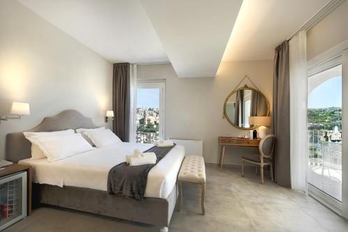 a bedroom with a bed and a desk and a window at Itria Modica in Modica