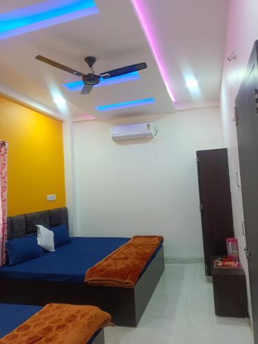 a room with a bed and a ceiling fan at JAI BHOLE HOME STAY in Ujjain