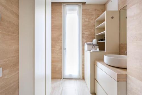 a bathroom with a white sink and a mirror at Luxury Flat Giardini D'Inverno in Milan