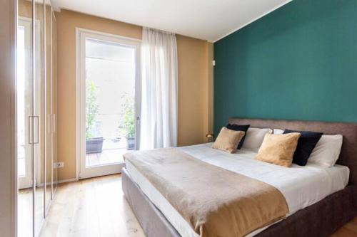 a bedroom with a large bed and a large window at Luxury Flat Giardini D'Inverno in Milan