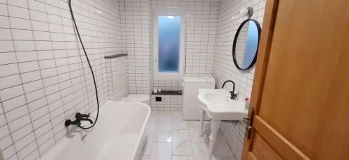 uma casa de banho branca com um lavatório, uma banheira e um WC. em Elégant, Lumineux,Central 2pièces à 200m de la mer em Menton